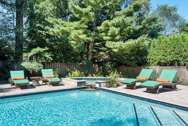 view of swimming pool featuring a patio area and an in ground hot tub