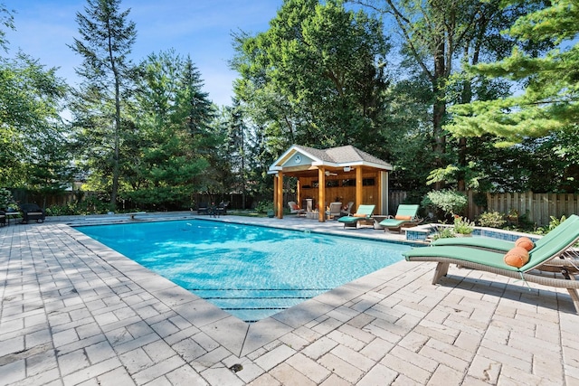 view of swimming pool with a fenced in pool, an outbuilding, a patio, a fenced backyard, and a storage structure