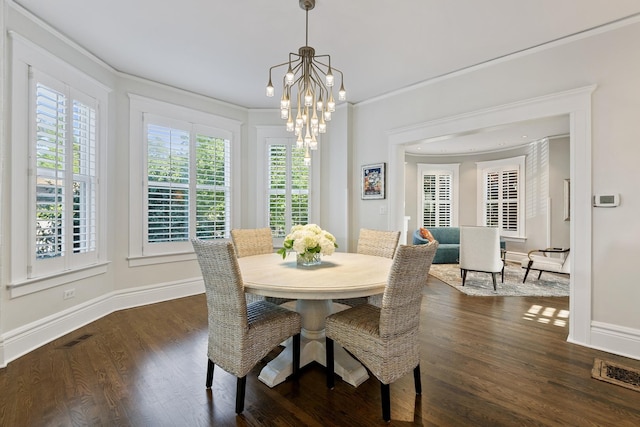 dining space featuring a notable chandelier, visible vents, dark wood-type flooring, ornamental molding, and baseboards