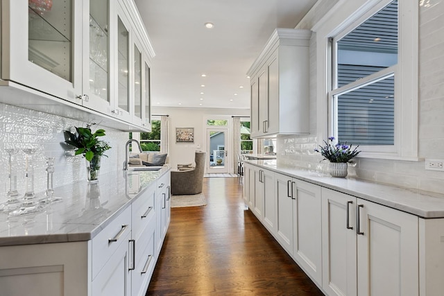 kitchen featuring dark wood-type flooring, glass insert cabinets, and white cabinets