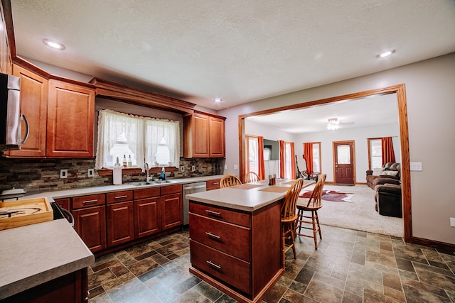 kitchen with stainless steel dishwasher, a wealth of natural light, backsplash, and dark carpet