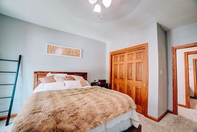 bedroom with ceiling fan, a textured ceiling, a closet, and carpet flooring