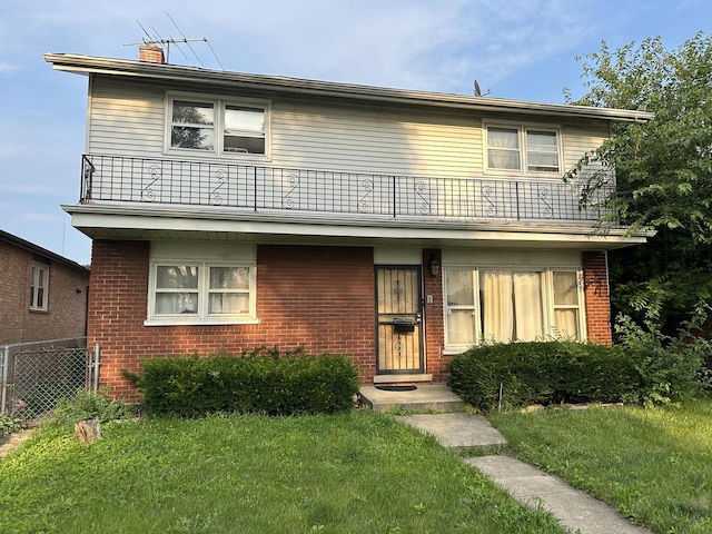 view of front of house with a front yard and a balcony