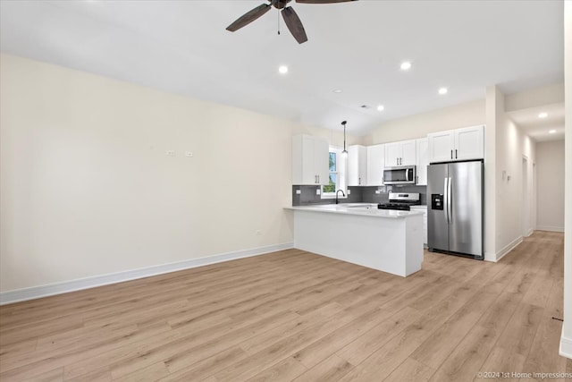 kitchen with light hardwood / wood-style floors, white cabinets, kitchen peninsula, and stainless steel appliances