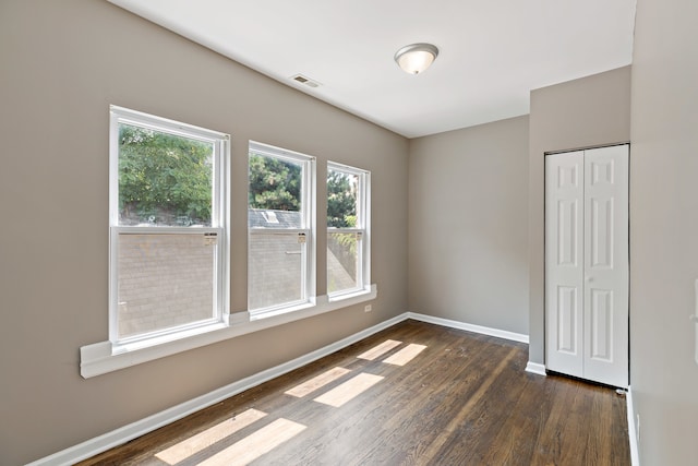 unfurnished bedroom with dark hardwood / wood-style floors and a closet