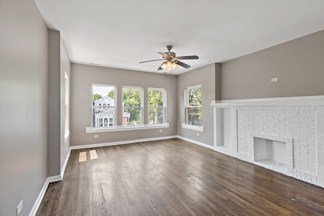 unfurnished living room featuring dark hardwood / wood-style flooring, a fireplace, and ceiling fan