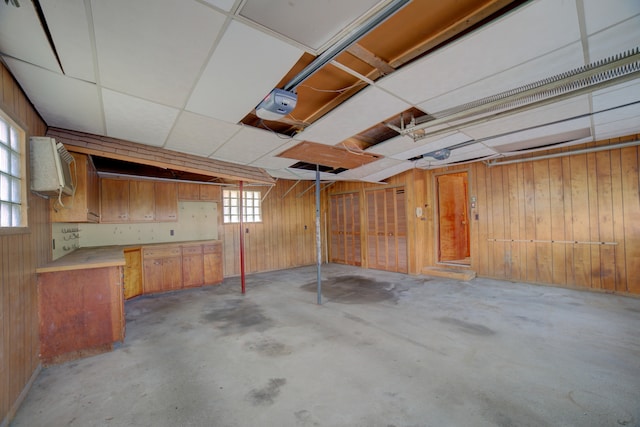 basement featuring a wall unit AC and wooden walls