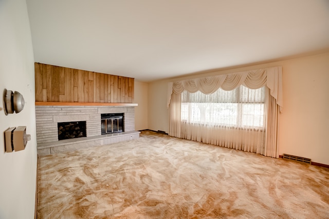 unfurnished living room with light carpet and a fireplace