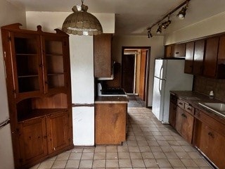 16631 Langley Ave, South Holland, IL 60473 - kitchen featuring dark countertops, brown cabinetry, tasteful backsplash, and freestanding refrigerator