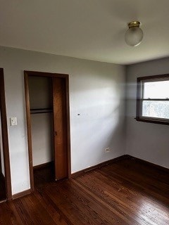 unfurnished bedroom featuring dark hardwood / wood-style flooring and a closet