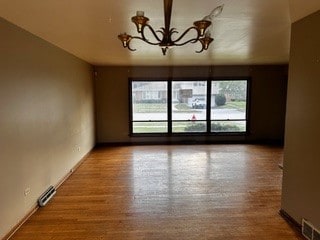 16631 Langley Ave, South Holland, IL 60473 - unfurnished room with an inviting chandelier, visible vents, and wood finished floors