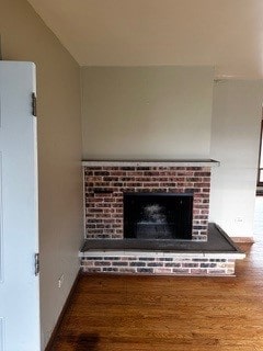 interior details featuring a brick fireplace and hardwood / wood-style floors