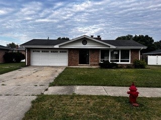 ranch-style house featuring a front lawn and a garage