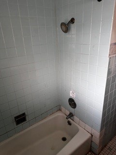 bathroom with tiled shower / bath combo and tile patterned flooring