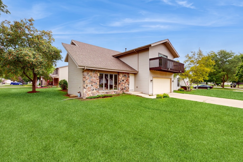 view of front of house with central AC unit, a garage, and a front lawn