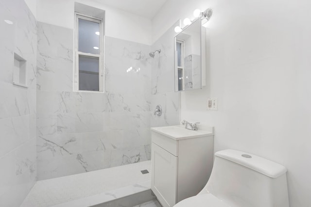 bathroom featuring tiled shower, vanity, and toilet