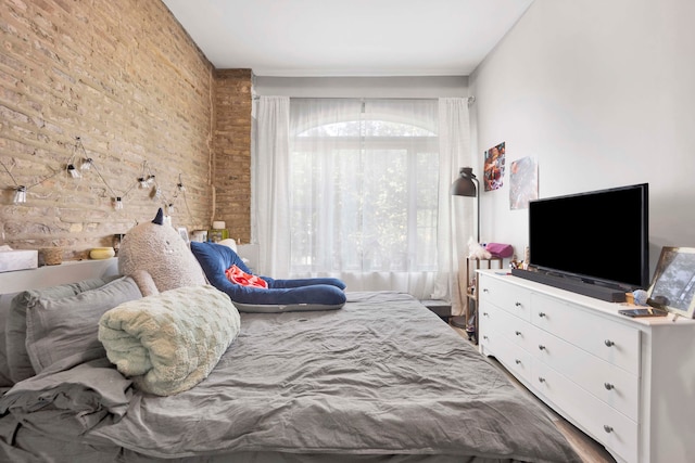 bedroom featuring brick wall