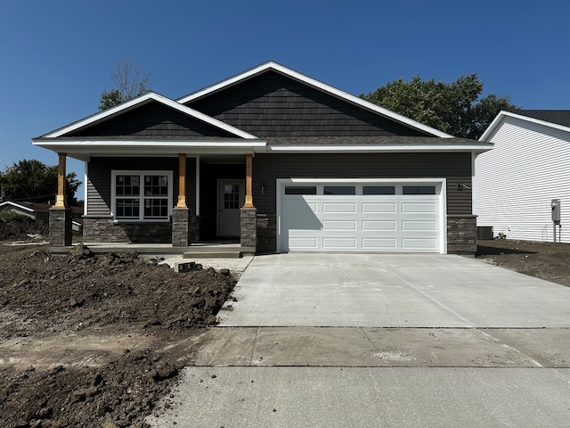 craftsman inspired home featuring cooling unit, covered porch, and a garage