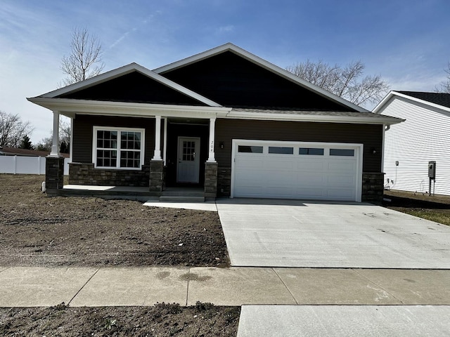 view of front of home featuring stone siding, covered porch, an attached garage, and concrete driveway