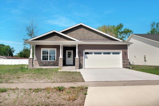704 Justice St, Tuscola, IL 61953 - craftsman-style house with stone siding, a garage, concrete driveway, and covered porch
