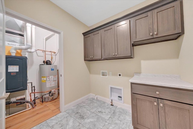 704 Justice St, Tuscola, IL 61953 - washroom with water heater, cabinet space, electric dryer hookup, baseboards, and washer hookup