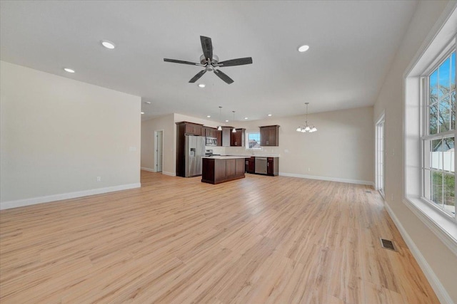 704 Justice St, Tuscola, IL 61953 - unfurnished living room featuring light wood finished floors, a chandelier, recessed lighting, baseboards, and ceiling fan