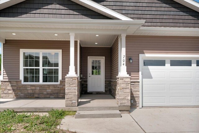 704 Justice St, Tuscola, IL 61953 - doorway to property featuring stone siding and a porch