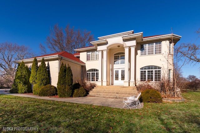 view of front of house with french doors, a patio area, and a front yard