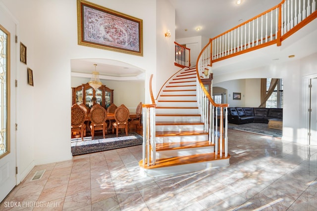 entryway featuring a high ceiling, crown molding, and a notable chandelier