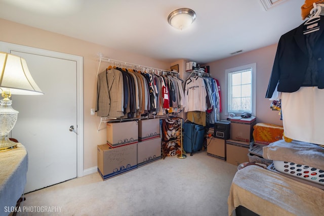 walk in closet featuring light carpet