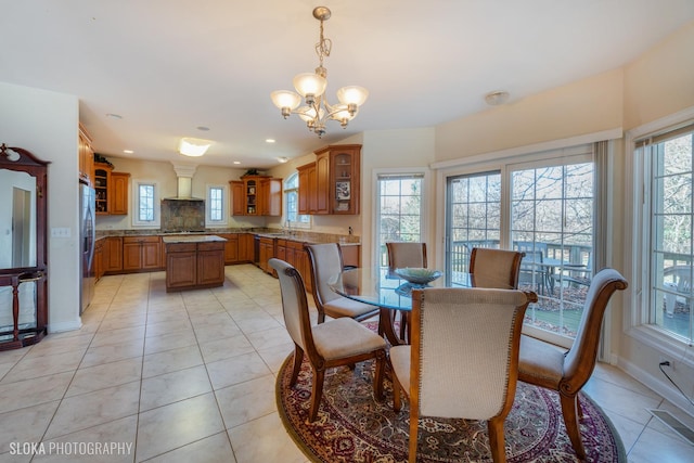 tiled dining space featuring an inviting chandelier and sink