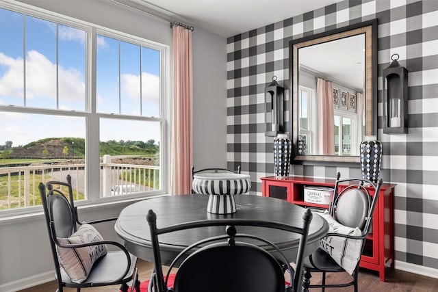 dining space featuring wallpapered walls, baseboards, and dark wood-style flooring