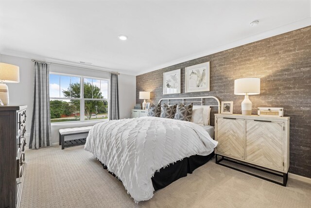 bedroom with light carpet, brick wall, and ornamental molding