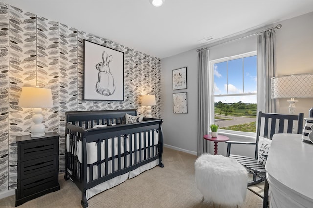 carpeted bedroom featuring an accent wall and baseboards