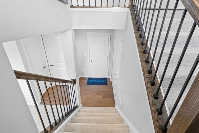 stairway with baseboards and wood finished floors