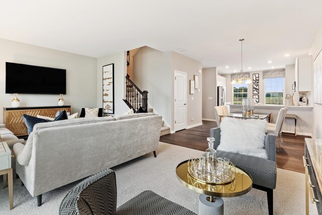 living room featuring an inviting chandelier and dark hardwood / wood-style floors