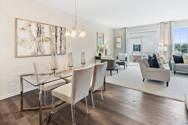 dining space featuring dark wood-type flooring and an inviting chandelier