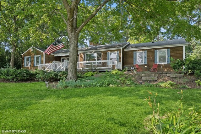 ranch-style house with a deck and a front lawn