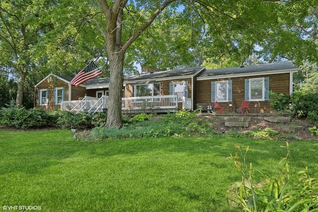 ranch-style house with a deck and a front lawn