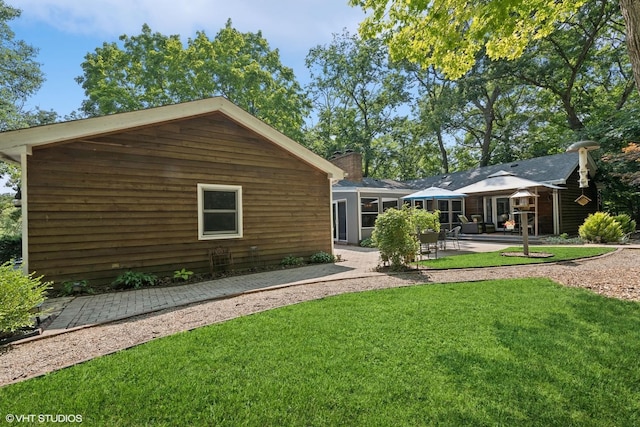 back of property with a patio area and a lawn