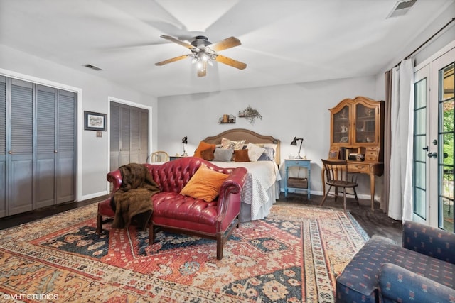 bedroom featuring ceiling fan, dark hardwood / wood-style flooring, and two closets