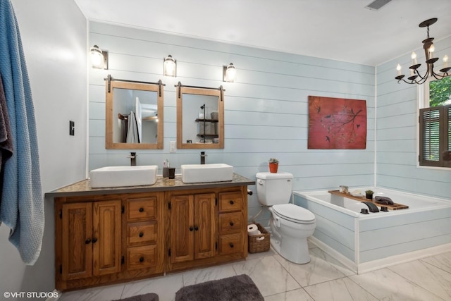 bathroom with vanity, a bathing tub, a notable chandelier, and toilet