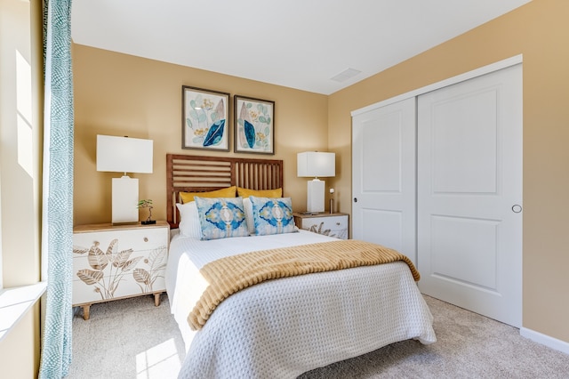 bedroom featuring light colored carpet and a closet