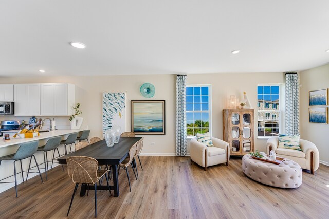 dining space with sink and light hardwood / wood-style flooring