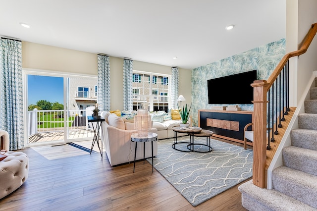 living room featuring a wealth of natural light, a high end fireplace, and hardwood / wood-style floors