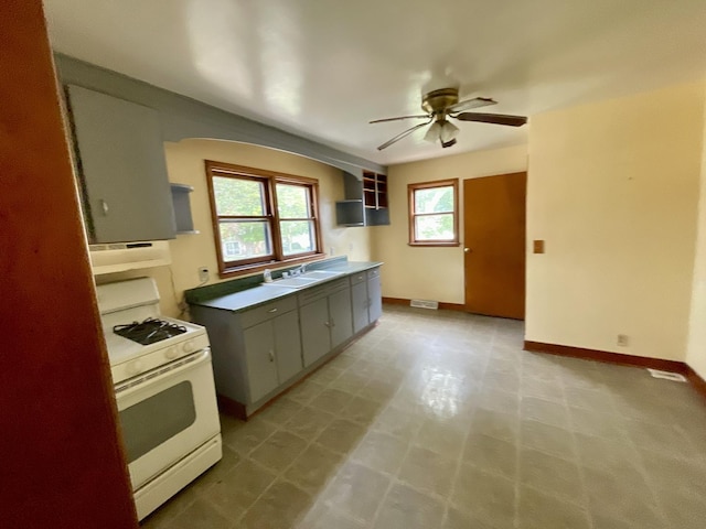 kitchen featuring a healthy amount of sunlight, sink, ceiling fan, and gas range gas stove