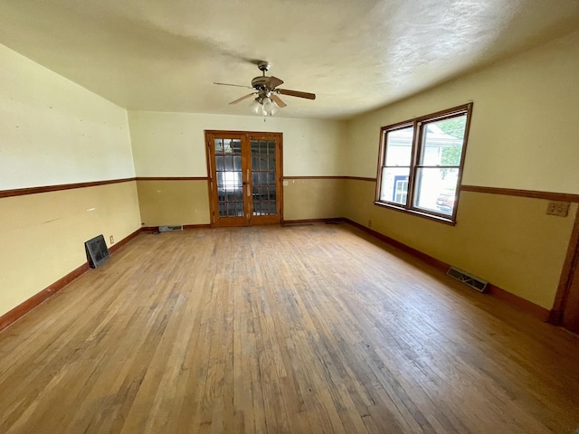 spare room with light hardwood / wood-style flooring, french doors, and ceiling fan