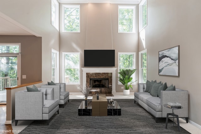 living room with a fireplace and a towering ceiling