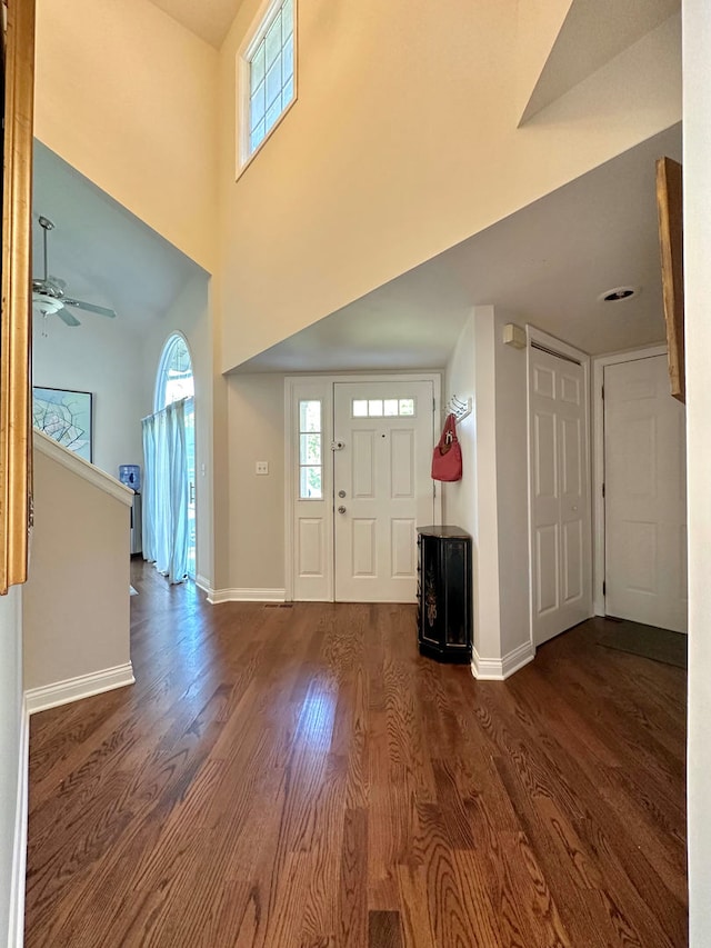 entrance foyer featuring a towering ceiling, ceiling fan, and dark hardwood / wood-style floors