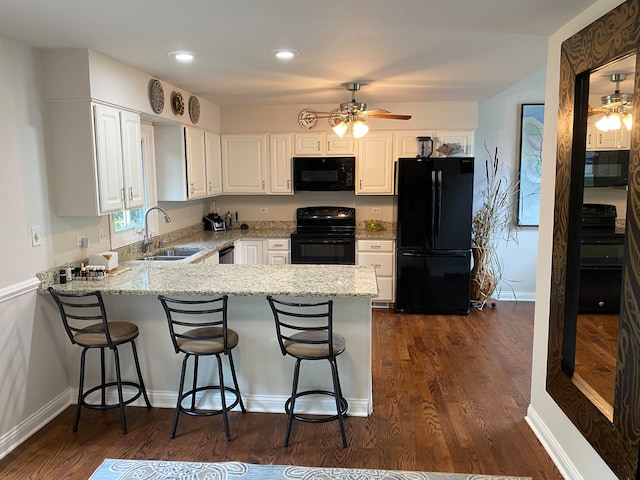 kitchen with white cabinets, black appliances, ceiling fan, and kitchen peninsula